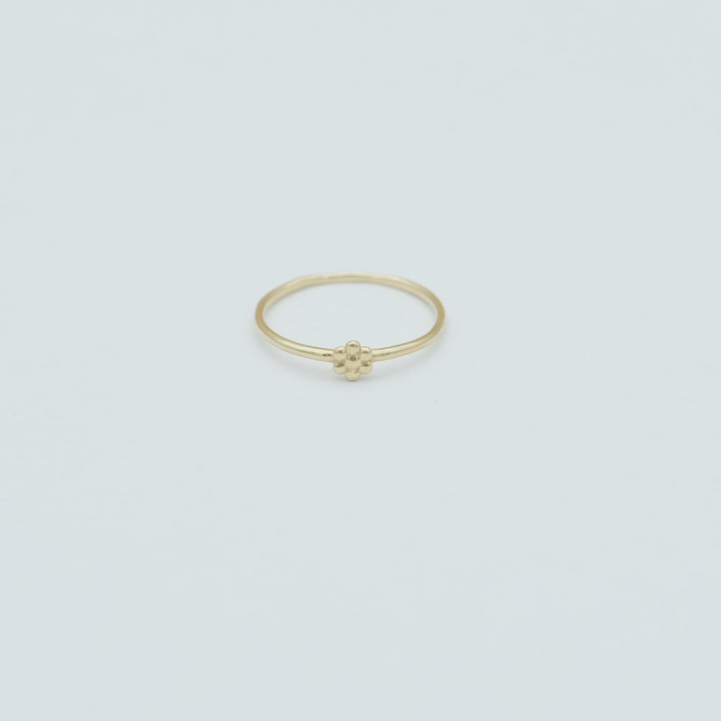 De massief gouden mini daisy ring is makkelijk om samen met andere ringen te dragen.